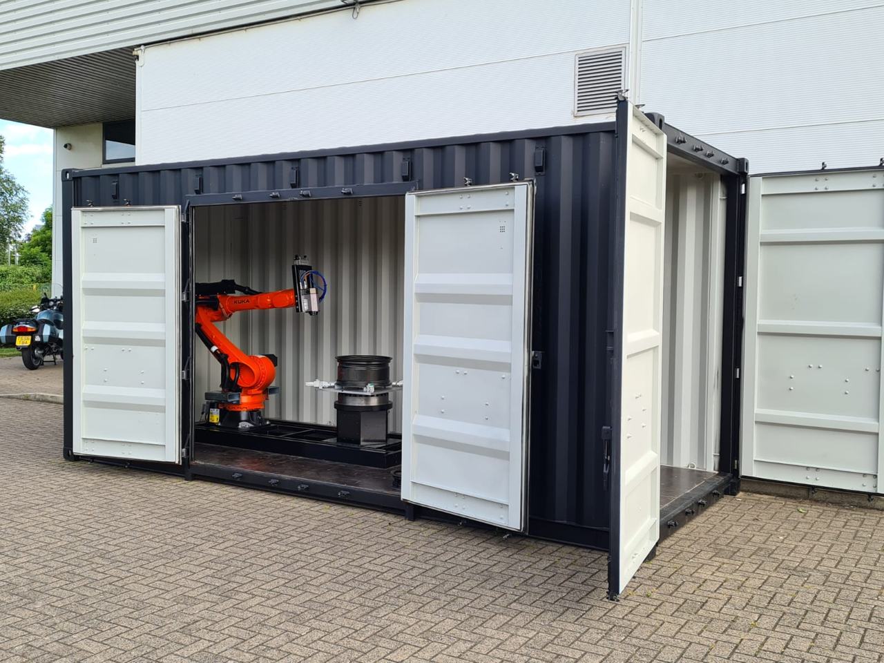 Containerised robotic milling cell with the doors open, robot installed inside