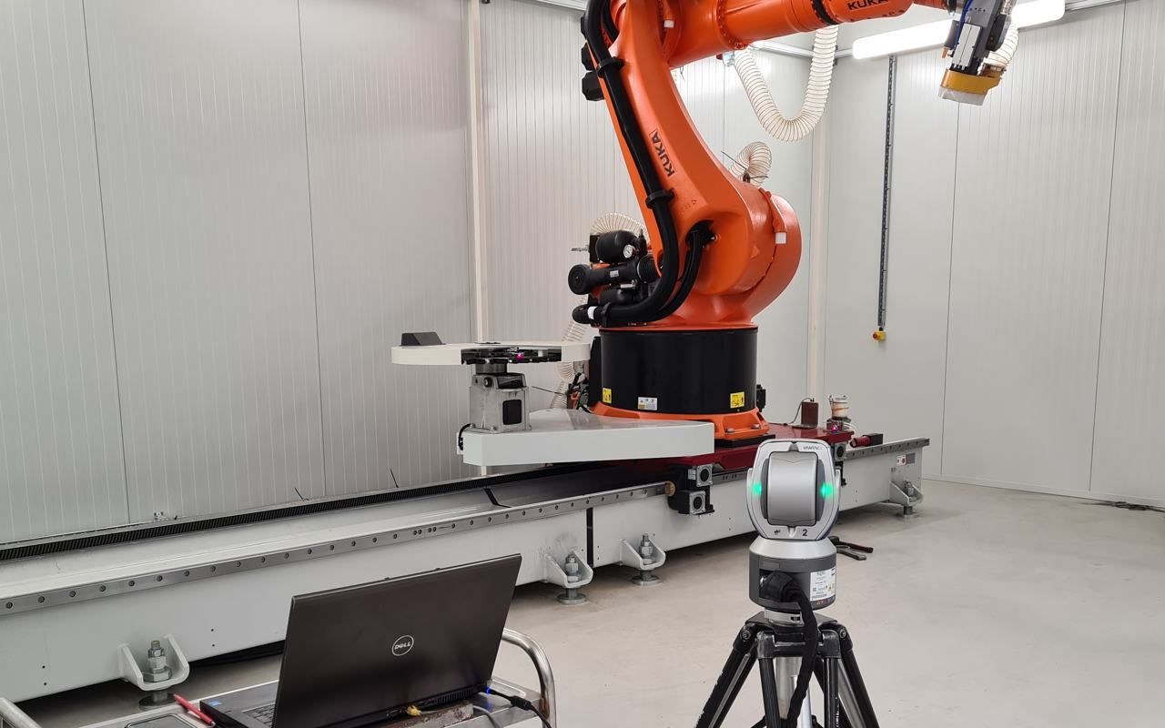 Laser tracker and laptop set up to calibrate a KUKA robot on a linear track during commissioning